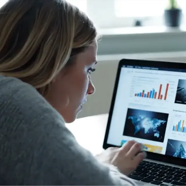 Lumi focusing on a laptop screen with charts, maps and data visualisations, for testing AXS Toolbar image descriptions.